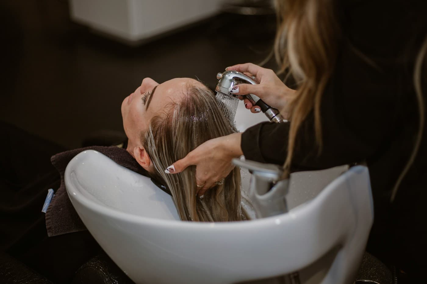 Client having her hair washed at a basin