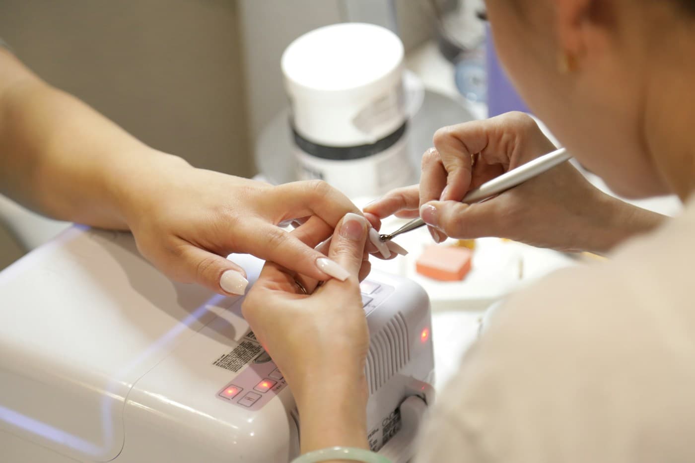 Nail technician filing a client's nails